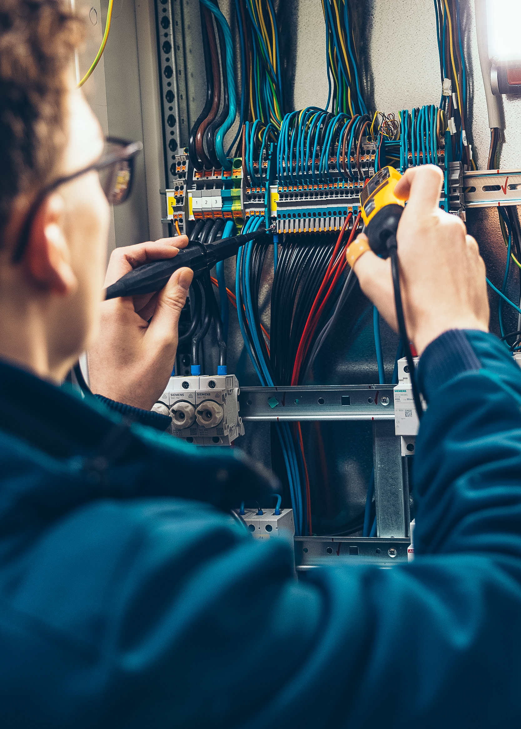 Elektriker Sebastian Laumbacher arbeitet in einem Schaltkasten